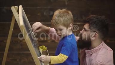 父子俩在黑板上用粉笔画。 小男孩和父亲的侧视图，用粉笔画图片
